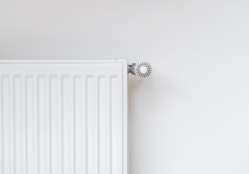 New modern radiator against white copy space wall. Central heating system in contemporary house. Saving energy, consumption of natural resource and warm home concept